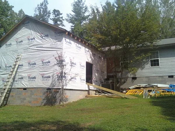 Tyvek wrapped gable on a new room addition beside an existing home in Jamestown